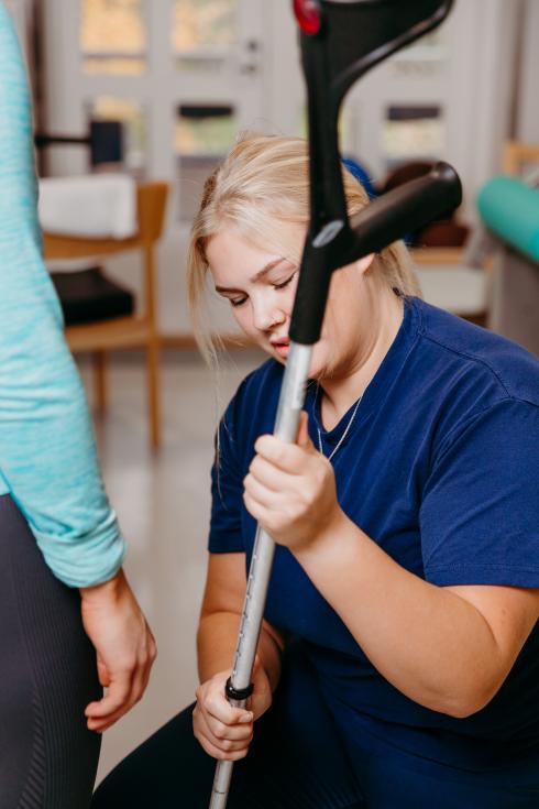 Sjukgymnasten vägleder klienten.