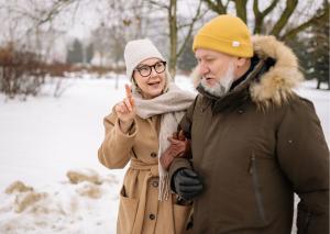 En kvinna och en man går utomhus på vintern i ett snöigt landskap.